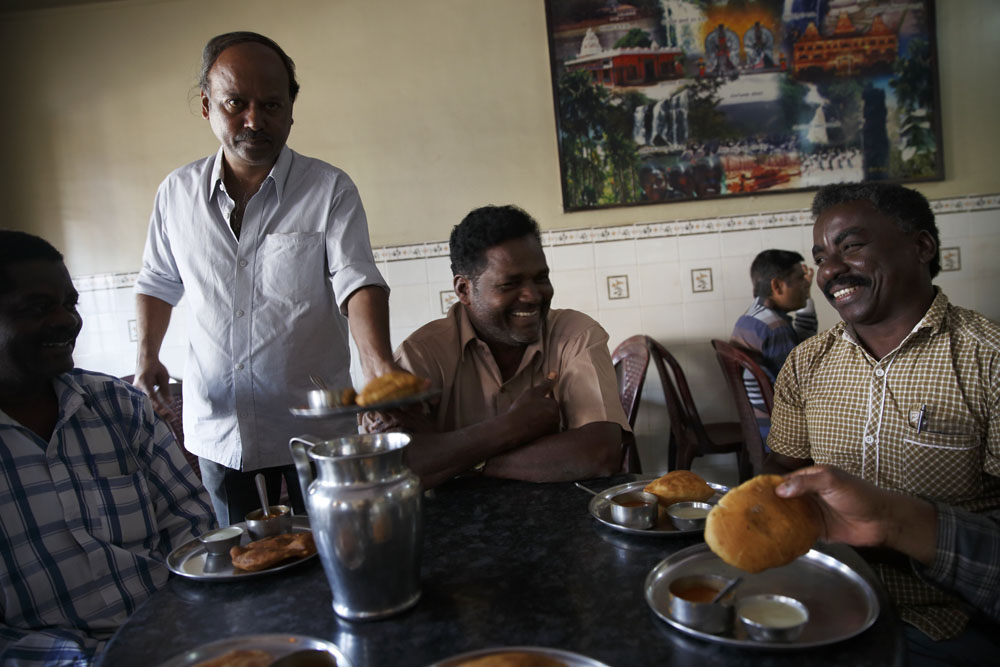 A group of Sidi men, leaders of a local Sidi development Society, have tea and snacks in a local restaurant. Uttara Kannada, India
