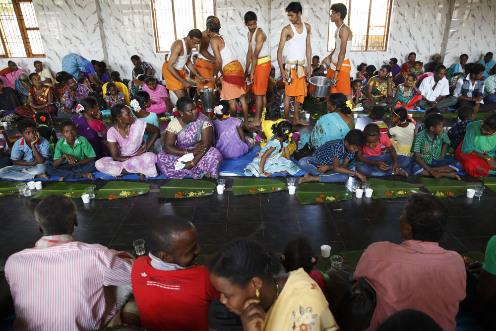 Wedding guests eat inside a wedding hall at a Hindu sidi weddingserved by the temples Brahmin helpers in the village of Idgundi. Uttara Kanada, India